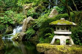 A tranquil scene from the Portland Japanese Garden with a running stream and moss-covered rocks.